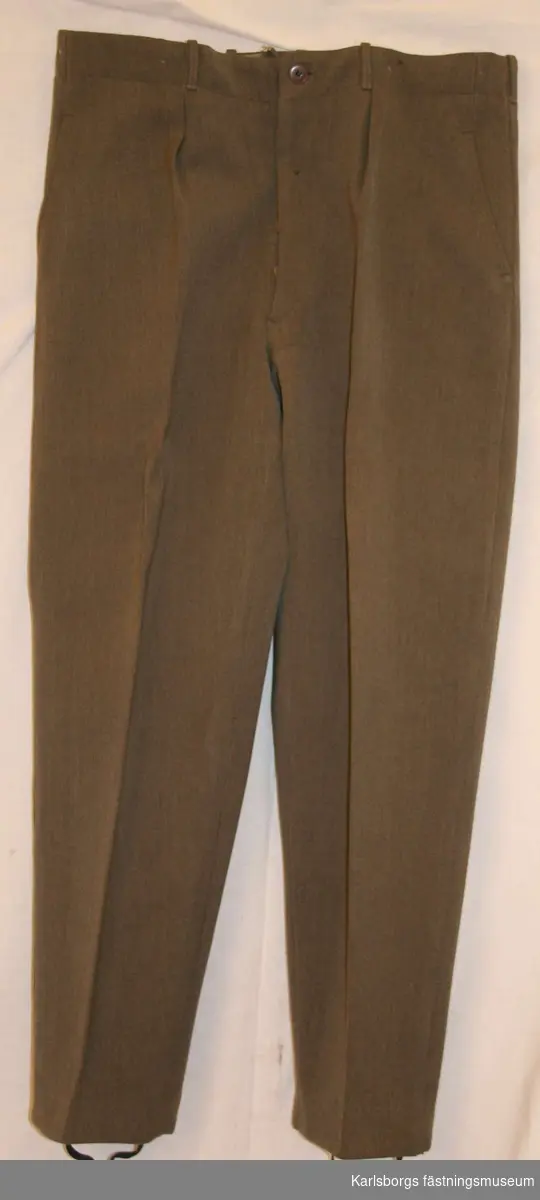 Långbyxa m/1939 - tillverkas av gråbrungrön diagonaltyg. Byxorna försedda med midjeband med knappar och knapphål. Blixtlås i gylfen. Samtliga byxor är försedda med sid- och bakfickor.