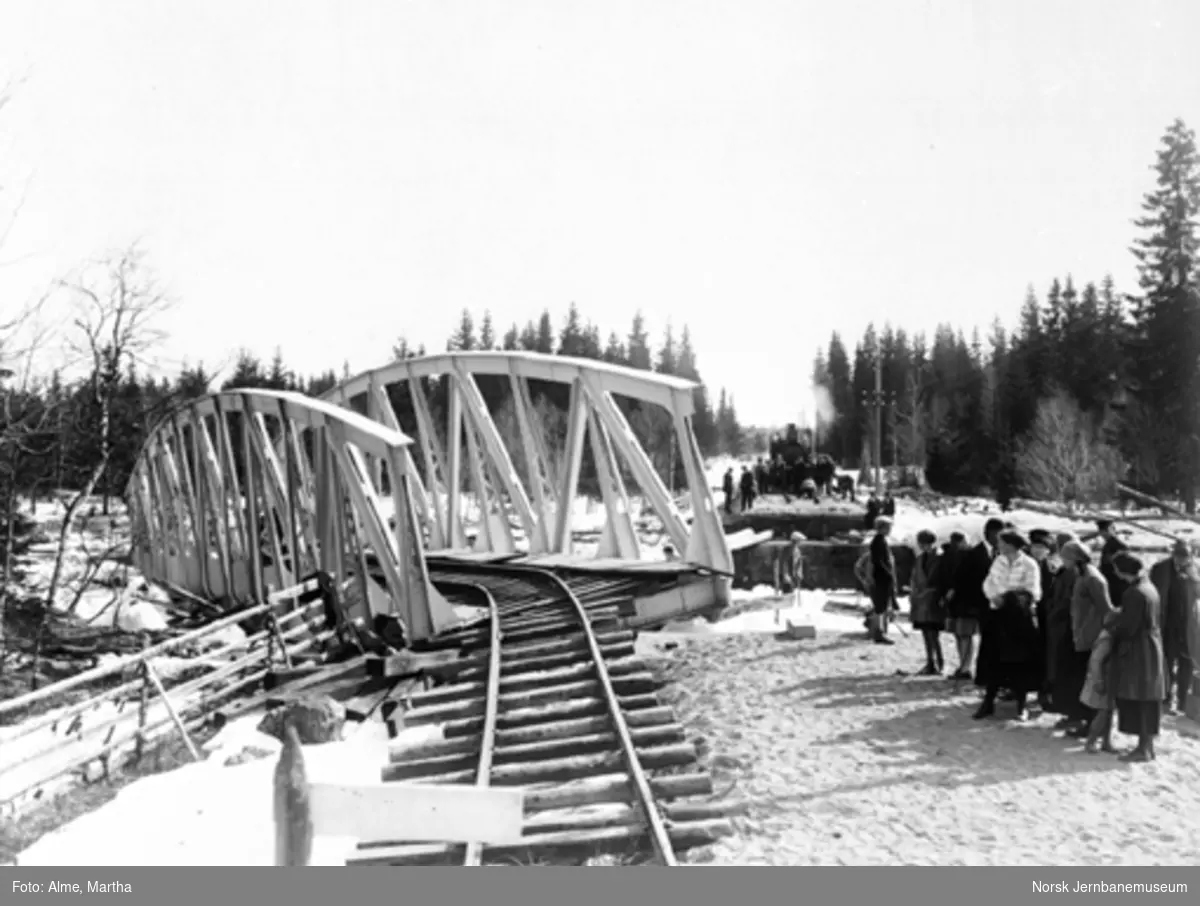 Hovda bru etter isgangen 28. april 1928 med et damplokomotiv på sporet på den andre siden av elva