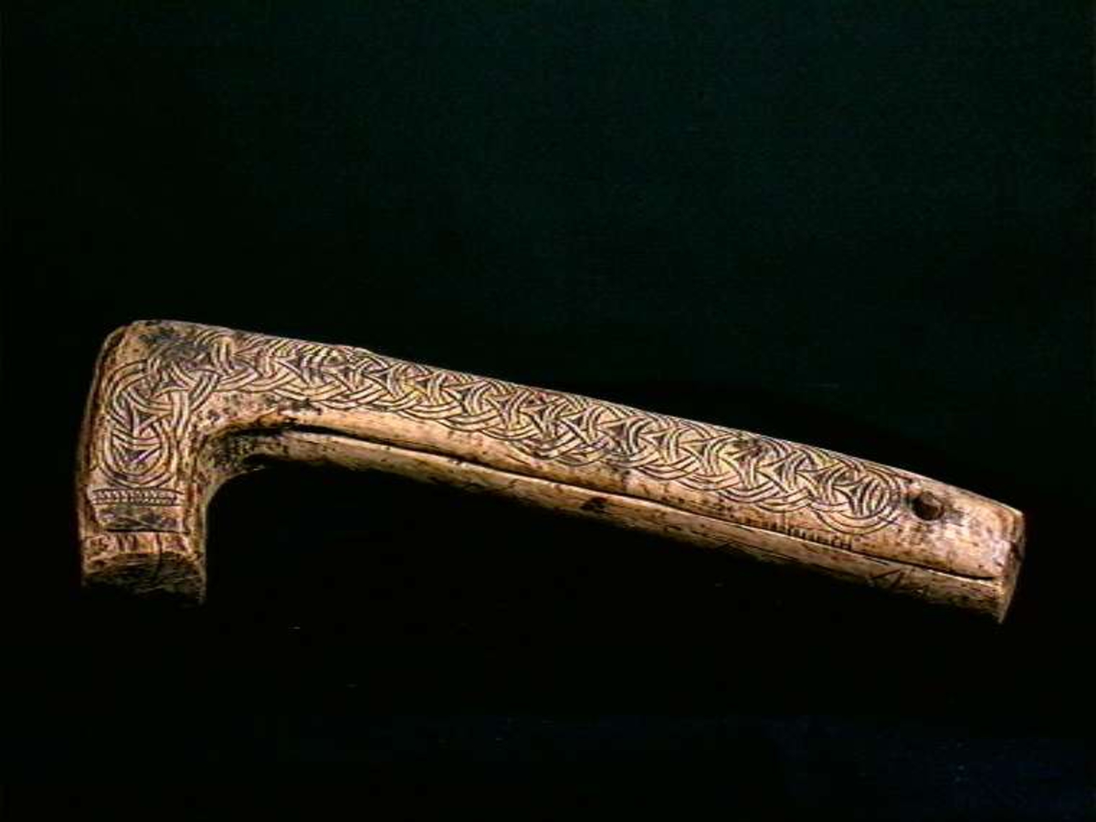 Skrin laget fra et trestykke tatt fra grenfeste. Lokket er skåret tangentielt fra trestykket og bunndelen er siden urholket. Lokket er festet i en dømling ved enden av den lange delen. Skrinet er dekorert med skurd kjedemønster. Dybdedelene i mønstret er forsterket med sot (kolrosingteknikk). Ellers ubehandlet treflater.