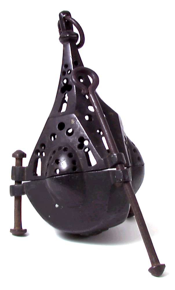 Bronse. 6 sidet. 3 av sidene med kuleformet utvidelse. Skål med pipe i centrum. Firpassformen viser hen på slutten av middelalderen. Den skjematiske og grove utførelse tyder på hjemlig produksjon. Ligger nær å gjette på Tunsberg. Etter reformasjonen er en lysepipe satt inn. Mulig denne lysestake har hengt etter en snor og likeledes den lange glidestangen