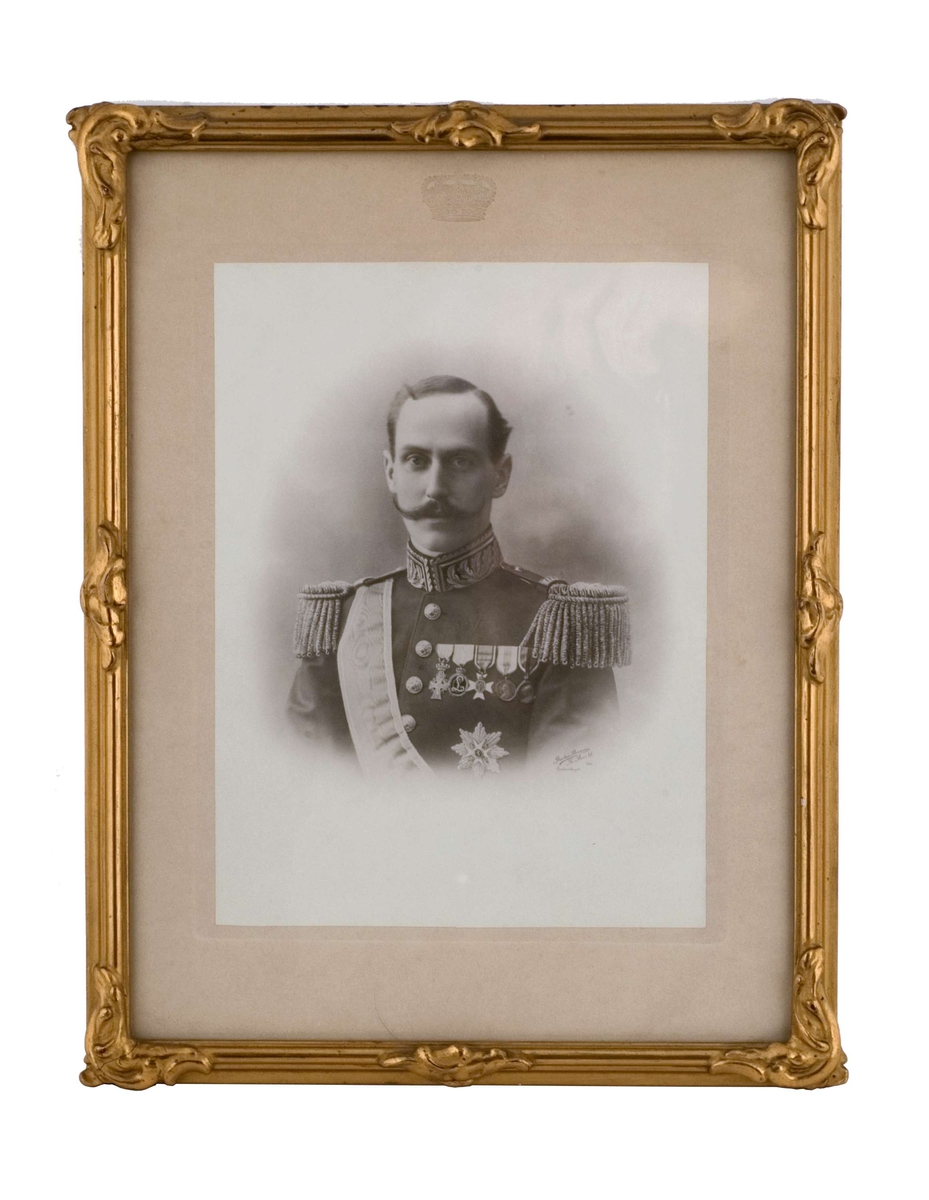 Portrett av kong Haakon 7 i uniform med ordensbånd. Ordener og medaljer på uniformsjakken. 