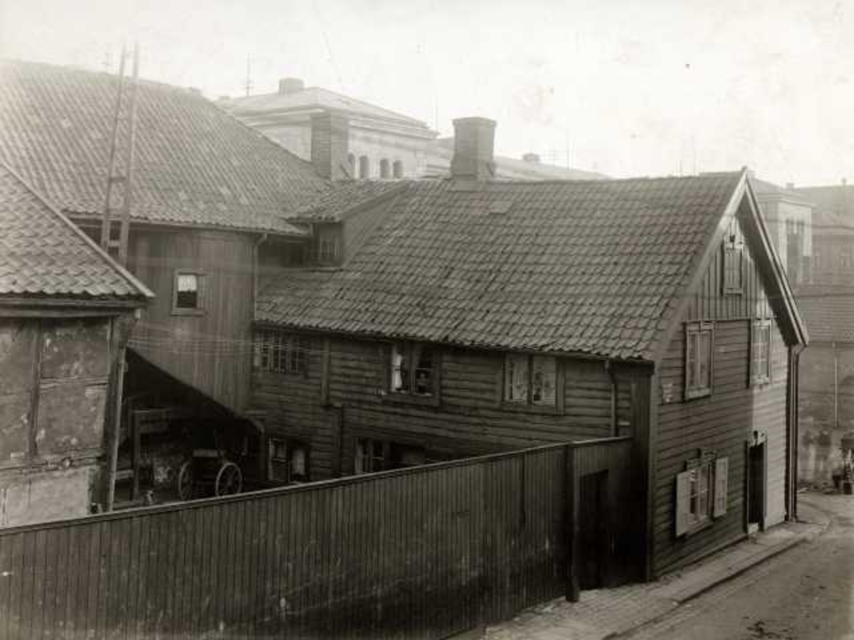 Hospitalgata 10, Oslo. Hjørnegård i tre med gårdsrom bak plankegjerde og uthus,