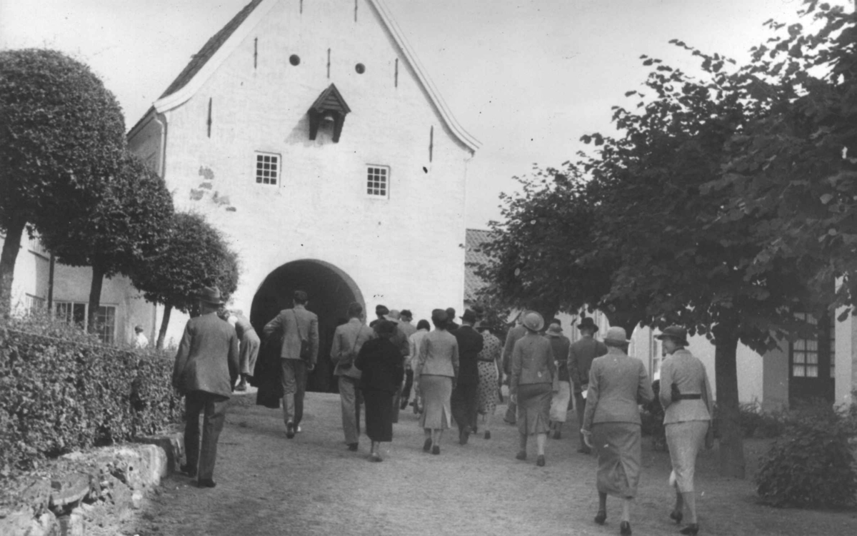 Turister ved (innsiden av) hovedinngangen til Norsk folkemuseum (Bergensporten), 1937.