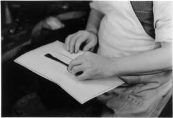 Skjearbeider kontrollerer skje mot tegningen. Gullsmedverkst