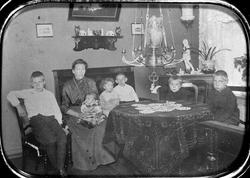 Stueinteriør med kvinne og 6 barn, Stoler, sofa, bord, kommo