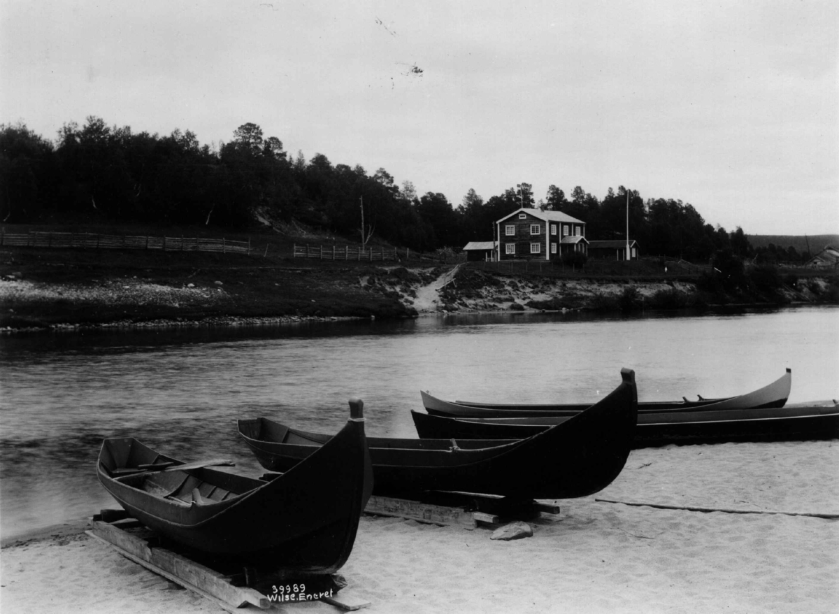 Båter. Fire nyoverhalte elvebåter på land. I bakgrunnen en bolig. Karasjok 1933.