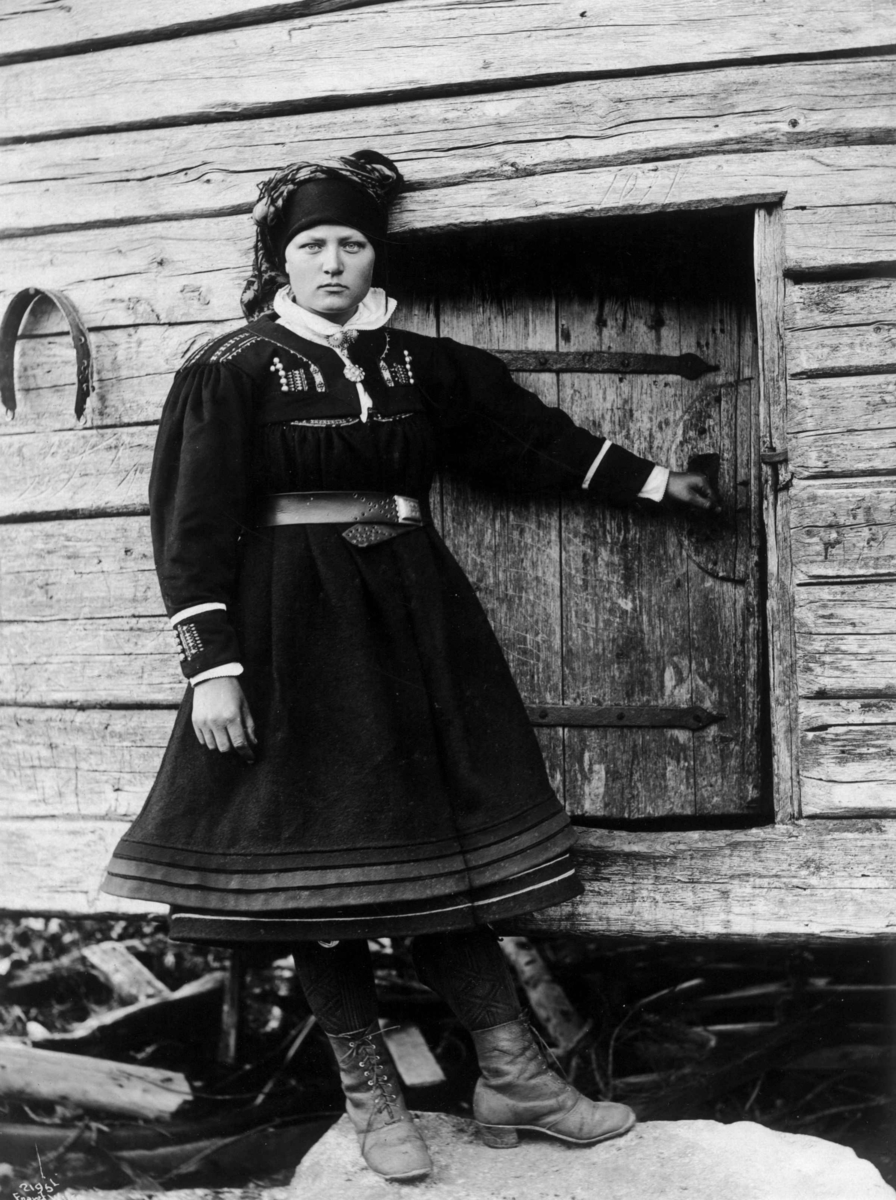 Kvinne i folkedrakt fra Setesdal på stabburstrapp i 1888.