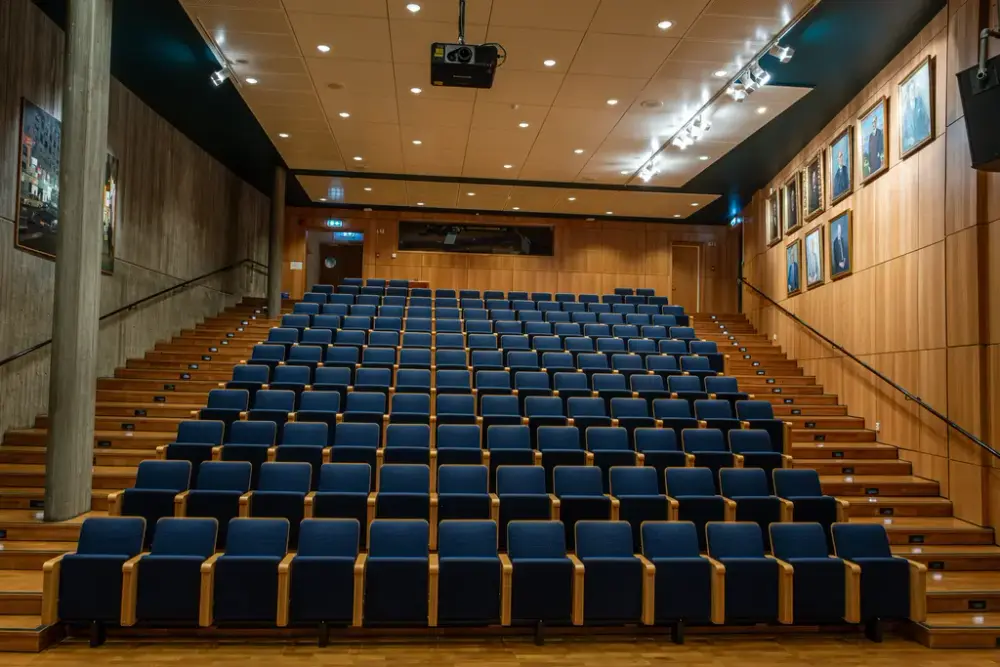 Bildet viser et auditorium på Norsk vegmuseum, med blå seter.