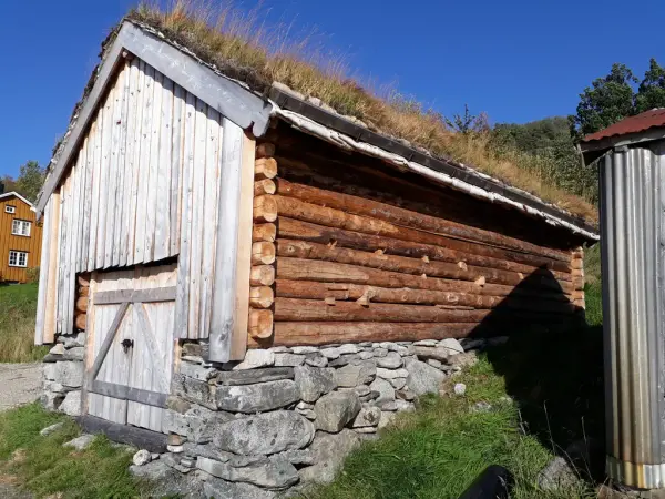 En laftet løe i et gårdsmiljø