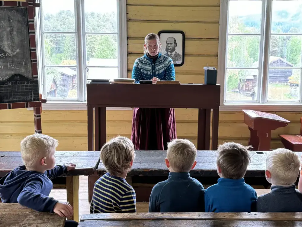 Skolelærer og barn i historisk klasserom