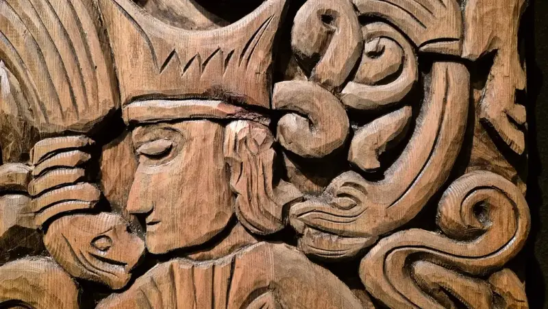 Utskjert i tre er Gunnar Gjukesson omringet av ormer