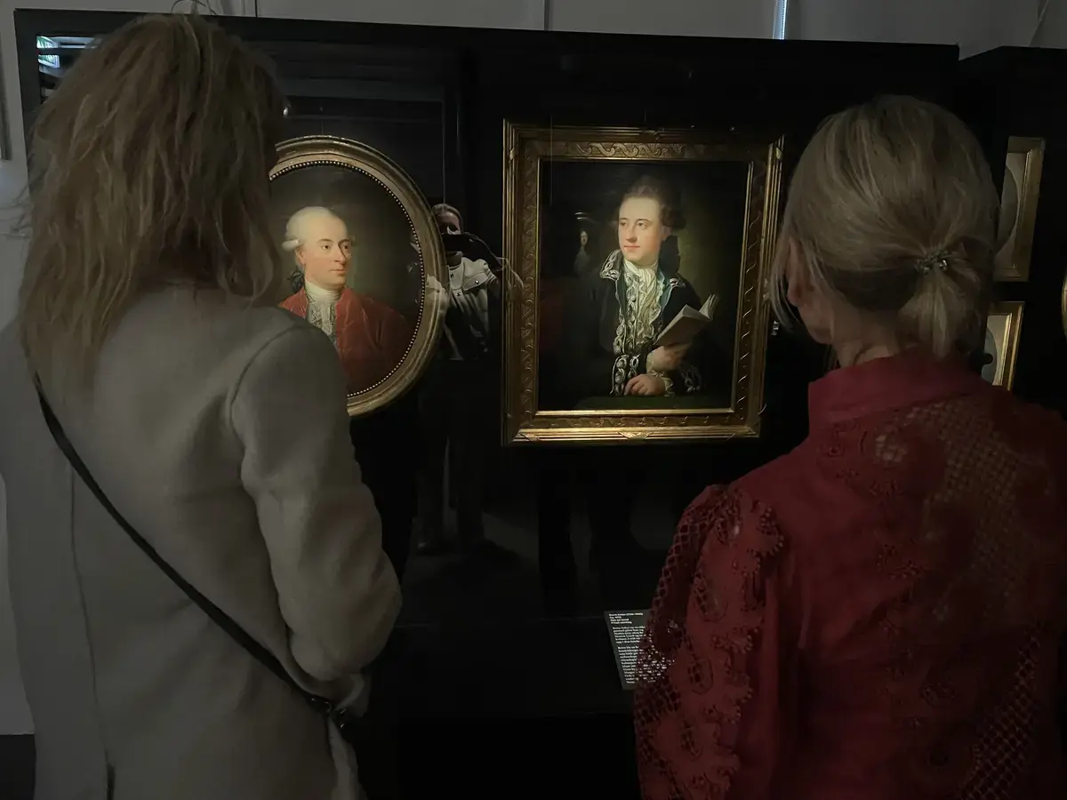 To besøkende studerer portretter av Jens Juel i utstillingen på Bogstad Gård.