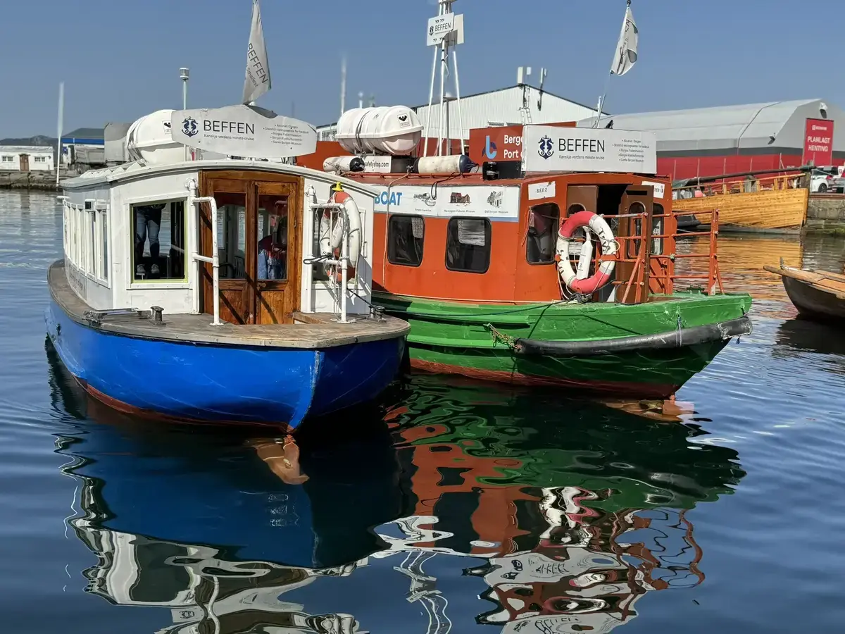 To båter, kalt BEF, ligger på en solfylt dag i havnen ved museet